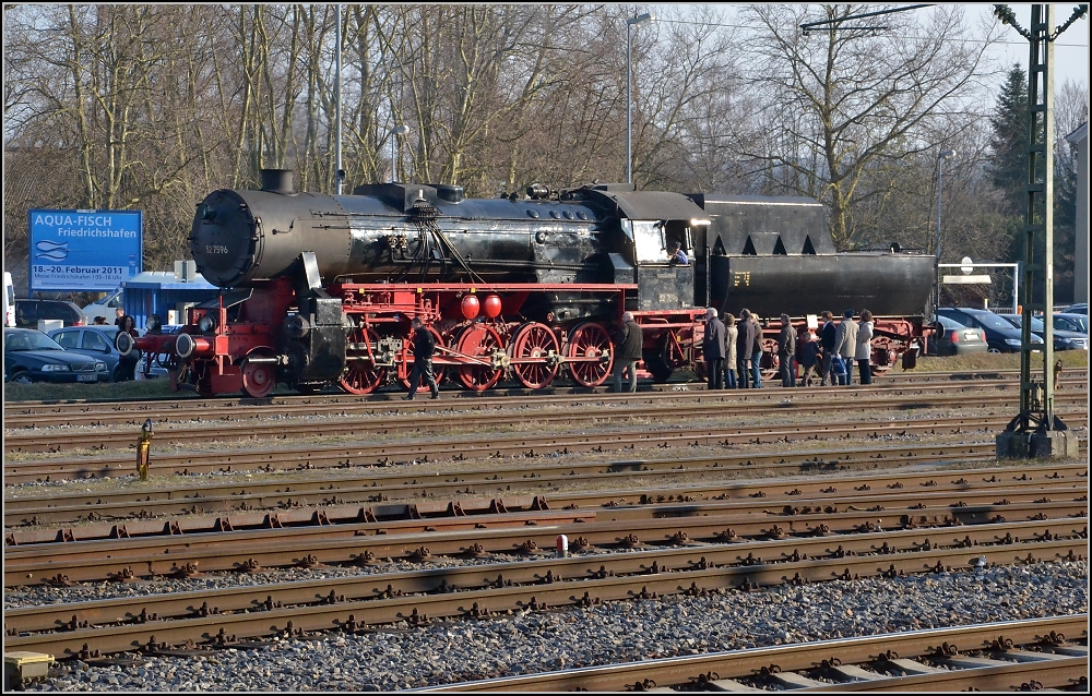 Winterfahrt zu den Eidgenossen (I). Parkplatz nebst Parkplatz. In Konstanz gibt es da keine Berührungsängste... Die 52 der Eisenbahnfreunde Hohenzollern wartet auf ihren Zug.