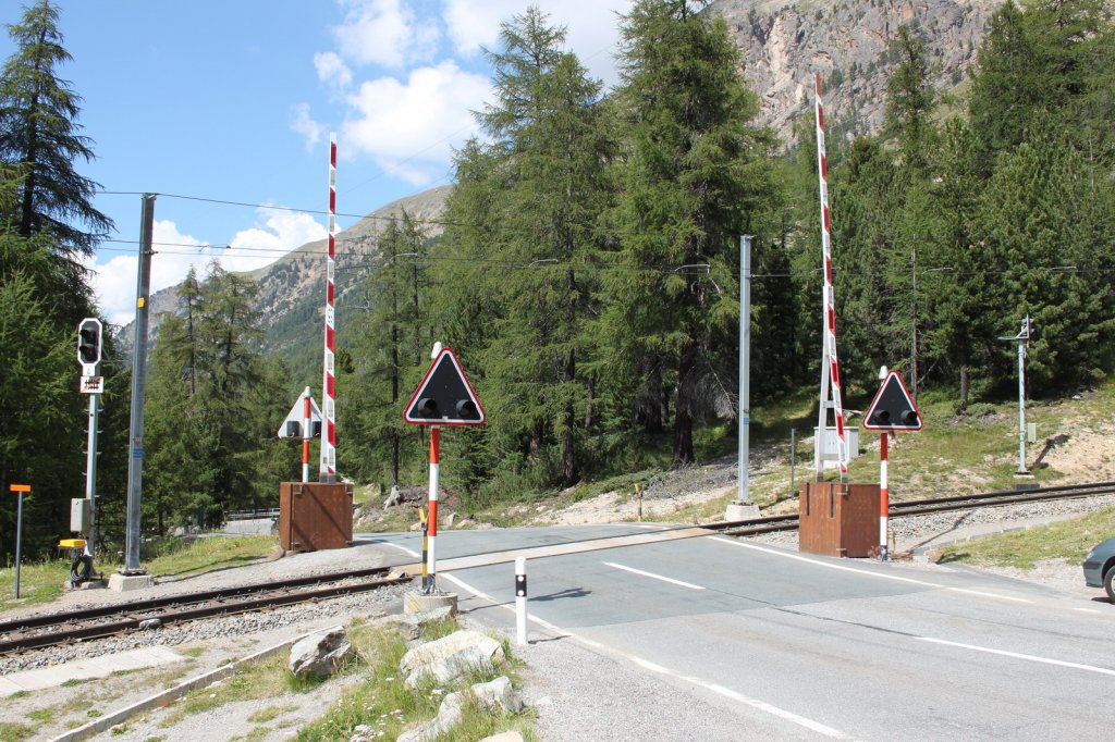Wohl bei allen RhB Freunden bekannt,der Bahnbergang an der Berninapass Strasse bei der  Montebello (Schner Berg)Kurve.17.08.11