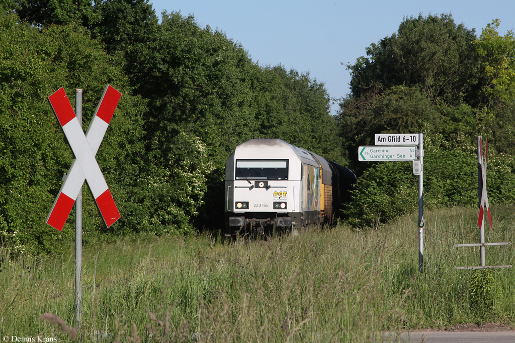 Ziemlich eingewachsen mit hohen Gras ist in einigen Abschnitten das Anschlussgleis von Lohhof ins BMW Werk. PCT 223 155 hat soeben mit einigen Autowagen das Werk verlassen und ist nun auf dem Weg Richtung Lohhof. (13.06.2013).