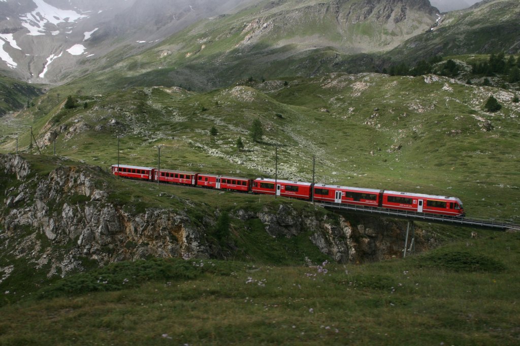 Zug 1632 ist der erste durchgehende Zug Tirano - St. Moritz am Morgen. Mit einem Allegra-Triebzug bespannt, berquert der Zug soeben die Brcke ber den Berninabach bei der Alp Bondo. Am  Reisezugschluss  (es folgen noch einige Gtewagen) luft einer der 10 frisch revidierten B EWIII. Aufnahme am 28.7.2010. 