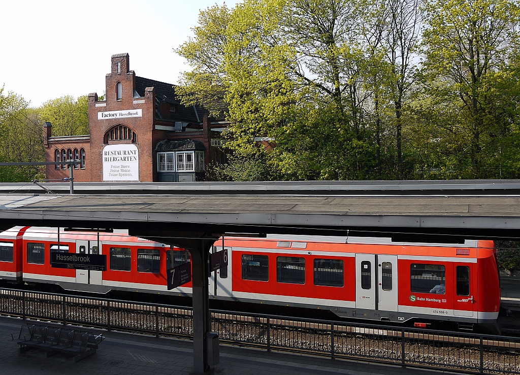 Zug der Hamburger S-Bahn im Bahnhof  Hasselbrook . Der Bahnsteig vorne dient dem Fernverkehr von und nach Lbeck. Im Hintergrund das ehemalige Stationsgebude - heute eine Kneipe. Dort, wo jetzt die Werbung  Restaurant Biergarten  prangt, fhrte frher eine Eisenfachwerkbrcke zu den Bahnsteigen - 1990 einfach abgebrochen. 19.4.2011  
