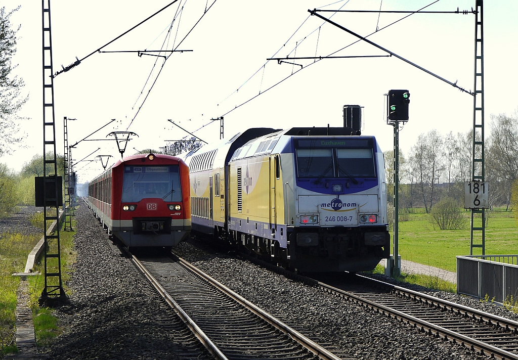 Zugbegegnung bei uerst schwierigen Lichtverhltnissen: kurz vor der S-Bahnstation  Fischbek  trifft ein Zweisystemzug der Hamburger S-Bahn auf einen Diesel-Metronom Richtung Cuxhaven. 28.4.2013