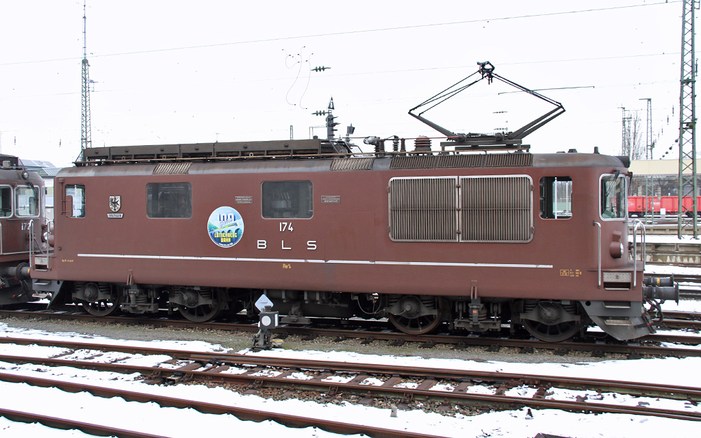Zum 100 Jhrigen Jubilum der Lschberg Bahn haben einige Loks der BLS einen grossen Kleber bekommen. So hier die Re4/4 174 Frutingen am 21.01.2013 im Bad Bhf bei Basel.