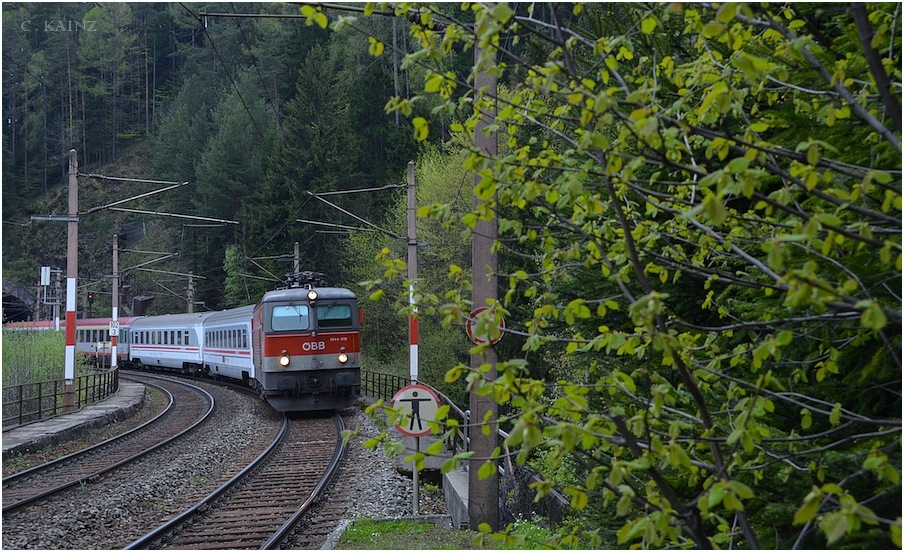 Zum 3000. Bild von Thomas Leitner, beglckwnsche ich Tom herzlich zu seinen vielen, in hchstem Mae anerkennenswerten und umfassenden Bildbeitrgen, und schalte mich aus aktuellem Anlass mal wieder mit einem Vergleichsbild vom April dieses Jahres vom  Wolfsbergkogel - Bogen ein: 

Anders als Tom, der mit den Masten nichts anzufangen wei, und sich zu sehr nur auf den Zug beschrnkt, war es mir als alter Detailfuchs, hier wichtig neben den wunderbaren Strukturen, der frischen, grnen Bltter, vor allem auch die prgnanten rotweissen Signaltafeln hereinzunehmen, die wie ich finde hervorragend zu den Farben, der verblichenen 1044 015 und der attraktiven Wagen des EC 158 Croatia passen. Dabei strt mich der Mast mitten im Bild, sowie das Schild nicht wirklich, da diese, wie ich finde in das Gesamtensemble durchaus annehmbar integriert sind ... 

lg, Christoph