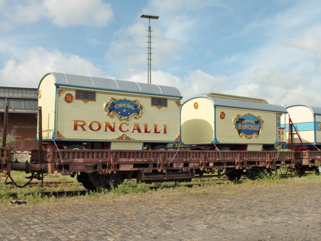 Zwei alte Circuswagen von Roncalli auf einem 2achser Niederbordwaggon am 24.05.2011 in Aachen West.