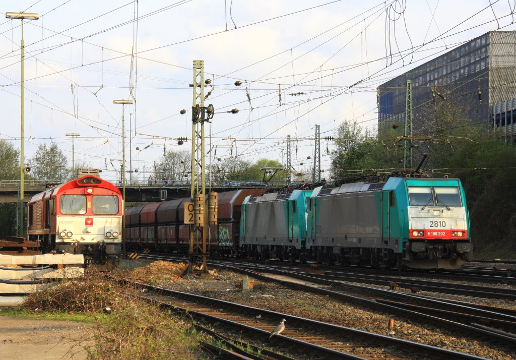 Zwei Cobra 2810 und 2843 kommen mit einem langen Kalkzug aus Yves-Gomeze(B) nach Millingen und fahren in Aachen-West ein und im Hintergrund steht eine Class 66 DE6312  Alix  von Crossrail mit Motor an in der Abendsonne am 23.4.2013.