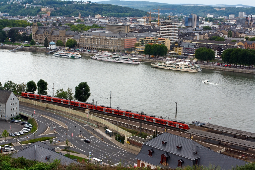 Zwei gekuppelte 425er-Triebzge als RE 8 (Rhein-Erft-Express) verlanssen am 13.08.2011 den Bf Koblenz-Ehrenbreitstein in Richtung Koblenz Hbf. Dafr mssen sie noch einen groen Bogen, dann ber den Rhein und wieder einen Bogen fahren, Hbf befindet sich in Bild oben links. Der RE 8 kommt ber Kln von Mnchengladbach Hbf. 