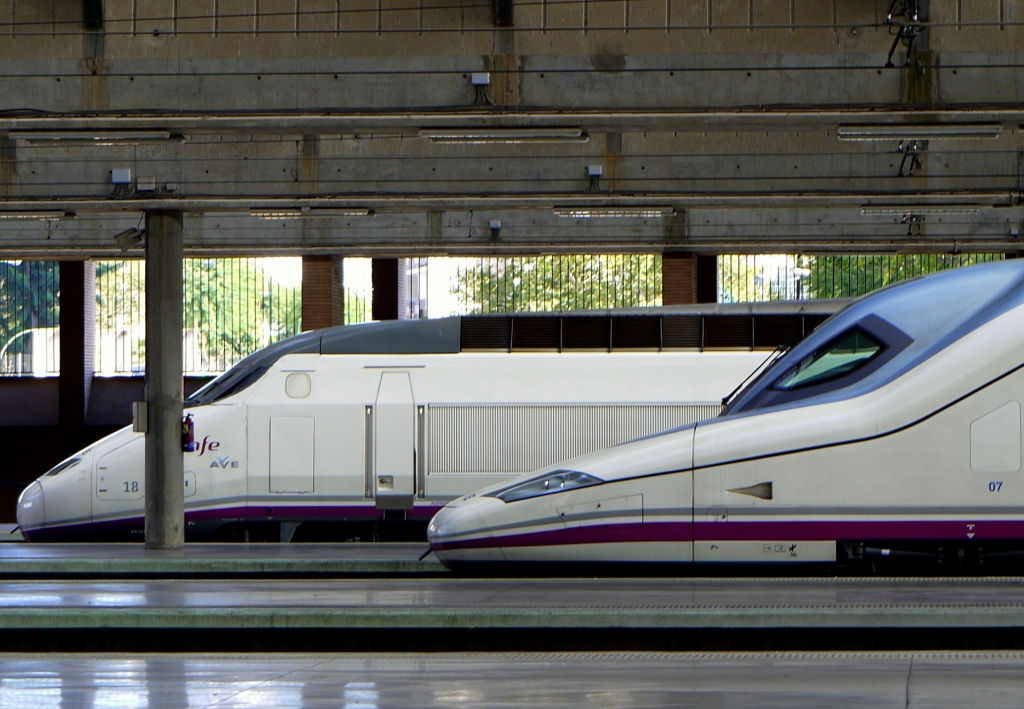 Zwei Hochgeschwindigkeitszge im Bahnhof  Sevilla Santa Justa . Hinten ein Zug der Baureihe 100 - hnlich dem franzsischen TGV Atlantique - vorne ein Triebkopf der Baureihe 102, gebaut von Talgo und Bombardier. 14.9.2012 