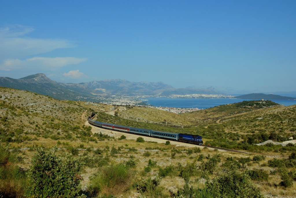 Zweimal pro Woche verbindet das  Adria  Zugpaar Split und Budapest. Am 24.07.2013 hat Zug 1205, gefhrt von 2044 023, die Bucht von Split schon bald verlassen und windet sich bei Sadine weiter ins Landesinnere.