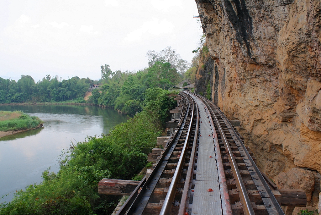 Zwischen den Bf. Saphan Tham Krasae und Tham Krasae ist die Strecke wegen der Enge zwischen dem Kwai Noi und dem Bergmassiv als Viadukt ausgefhrt. Blick in  Richtung Tham Krasae am 12.Mrz 2012. 

