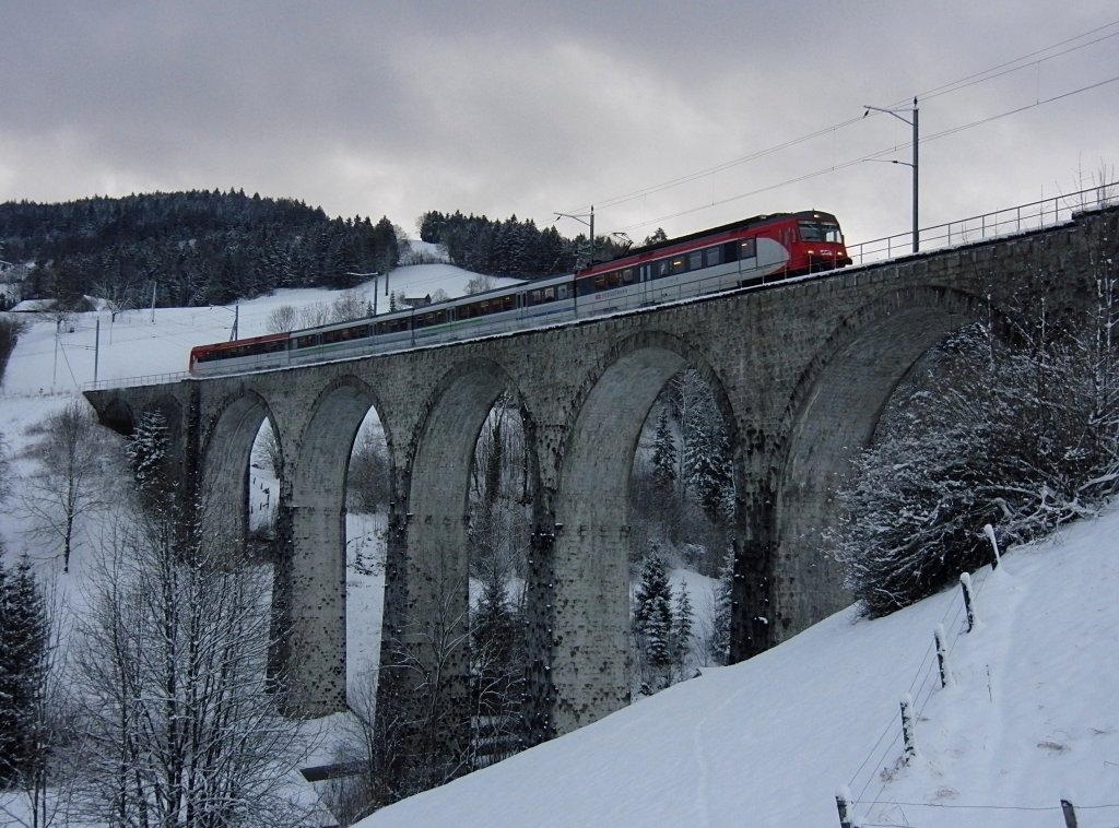 Zwischen Degersheim und Mogelsberg berquert am 18.12.2011 S4 23466 von St. Gallen nach Uznach den Waldbach-Viadukt.