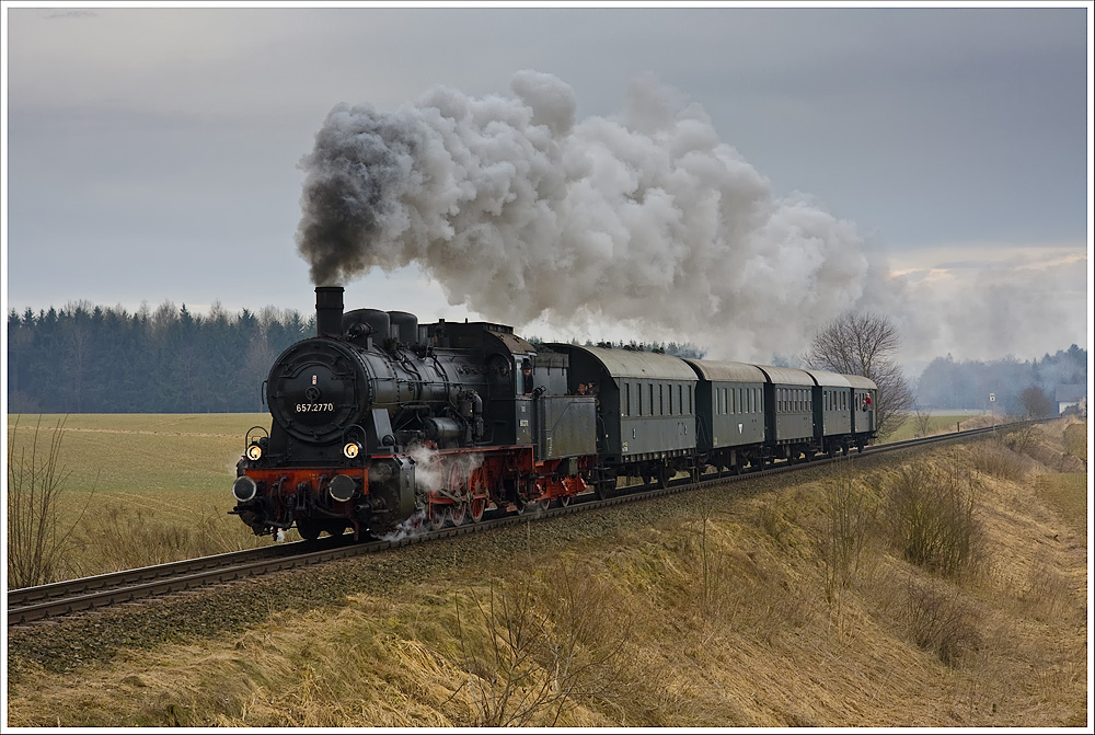 Zwischen der Hst. Mühlheim und dem Bhf Obernberg-Altheim dampft die 657.2770 mit dem R14312 (Braunau-Attnang-Puchheim) durch das trostlose Wetter des Innviertels. 13.3.2011