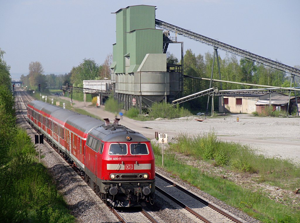 Zwischen Laupheim West und Biberach (Riß) passiert 218 406-7 mit dem IRE 4211 von Ulm nach Lindau am 05.05.2013 das Riss Kieswerk. Hinter der 218er ist bei diesem IRE zwischen dem 1. Mai und 20. Oktober an Samstagen und Sonntagen ein Fahrradwagen eingereiht.