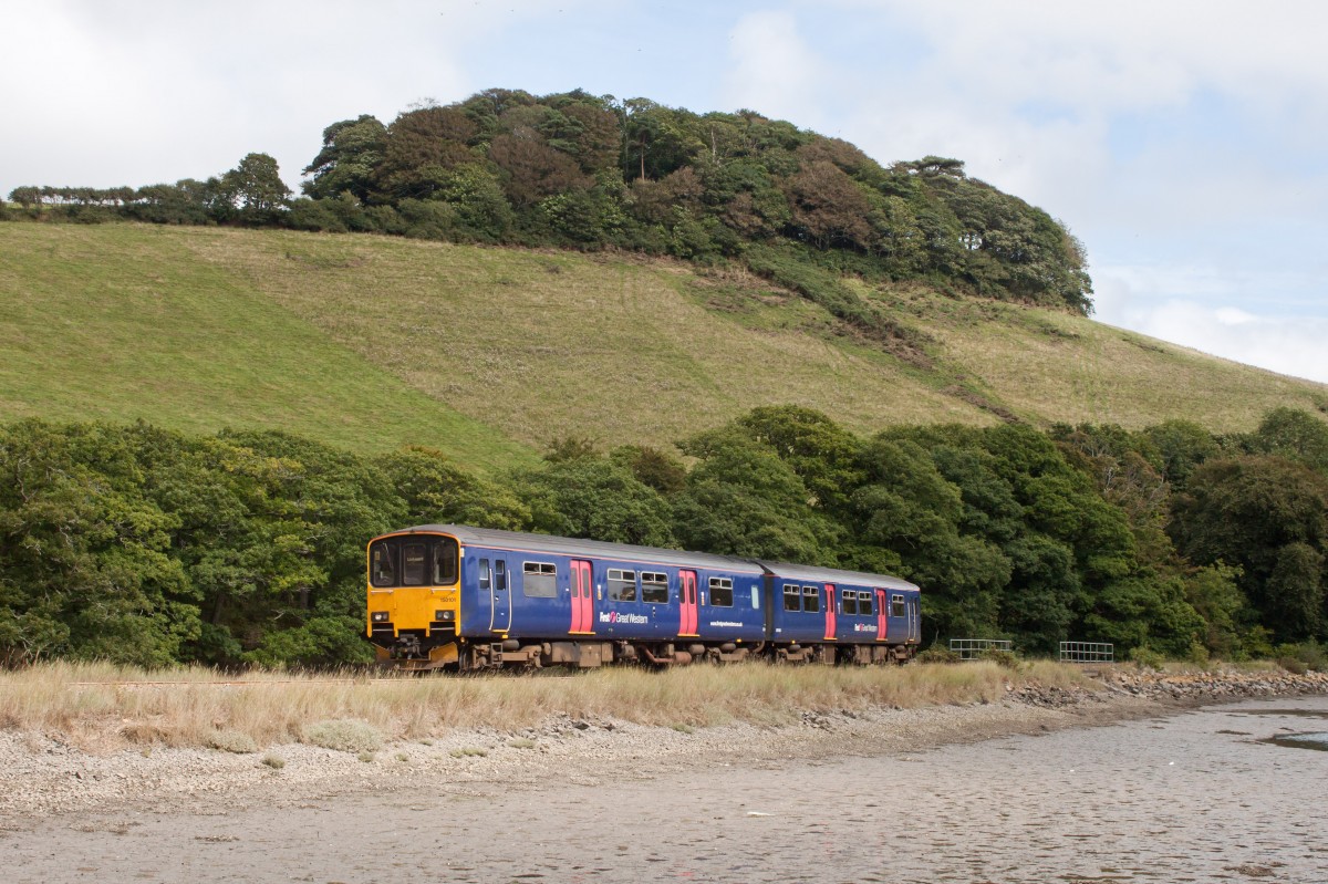 - Am Looe Estuary -
Die untersten Kilometer der Looe Valley Line verlaufen direkt entlang dem Fluss Looe oder kornisch Logh, der auch dem Ort Looe den Namen gab.
In seinem Unterlauf hat der Fluss die Form eines Ästuars, steht also unter dem Einfluss der Gezeiten. 
Zwischen dem Endbahnhof Looe und der Haltestelle Sandplace befindet sich der Bahnübergang Terras Crossing. Aufgrund der Unübersichtlichkeit der Situation hält dabei jeder Zug kurz vor dem Übergang an, gibt einen Warnton ab und fährt erst danach weiter. 
Hier konnte ich 150 101 unterwegs als 1457FGW-Service (Looe-Liskeard) bei diesem Manöver ablichten. 
30. August 2013