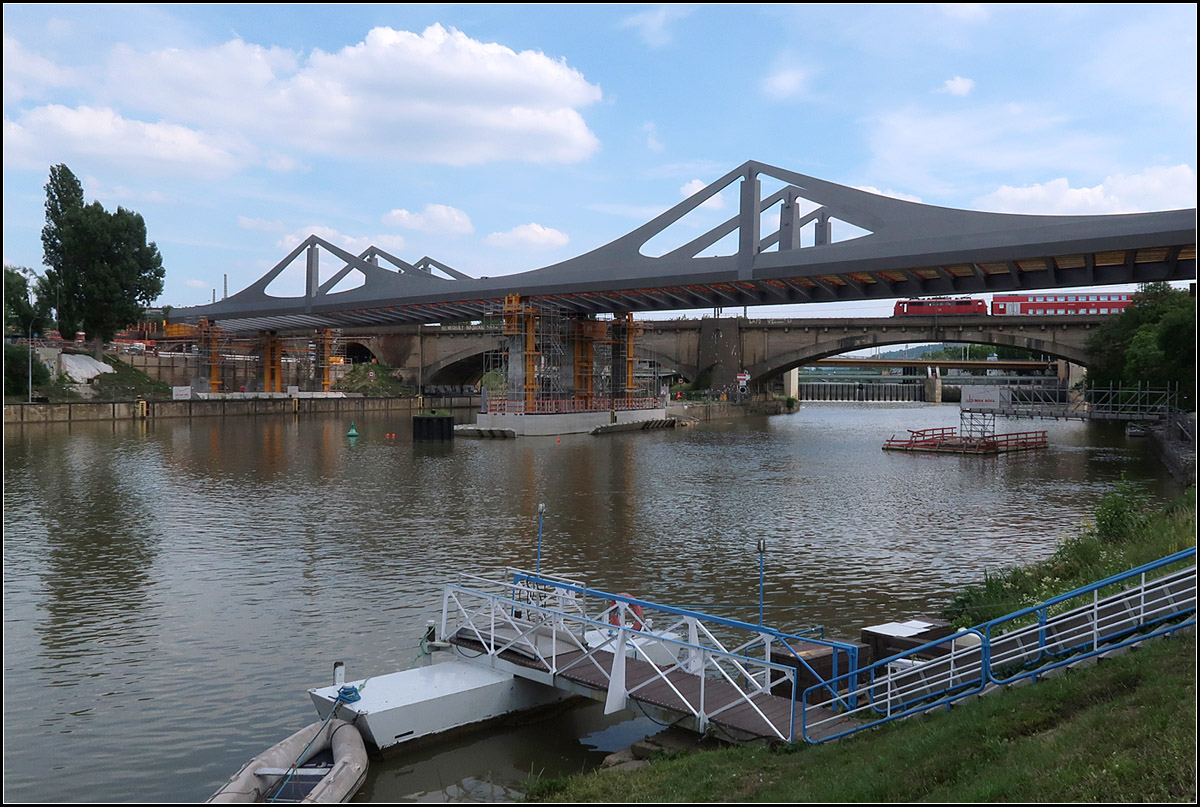 . Bald in Position -

Ein Stück weit muss die neue Brücke noch nach links geschoben werden, bis die Pylone genau über den Stützen positioniert sind, dann hat die neue Bahnbrücke über den Neckar in Stuttgart-Bad Cannstatt ihre endgültige Lage erreicht. 

Für eine Inbetriebnahme der Neubaustrecke von Wendlingen nach Ulm, bevor Stuttgart 21 selbst in Betrieb gehen kann, müsste allerdings aus fahrplantechnischen Gründen (eingleisige Verbindungskurve in Wendlingen) der S-Bahnverkehr auf die neue Brücke und die neue Tunnelstrecken zum Hbf umgelegt werden. Dadurch würden von Bad Cannstatt zum Hbf sechs Gleise zur Verfügung stehen.

16.06.2018 (M)