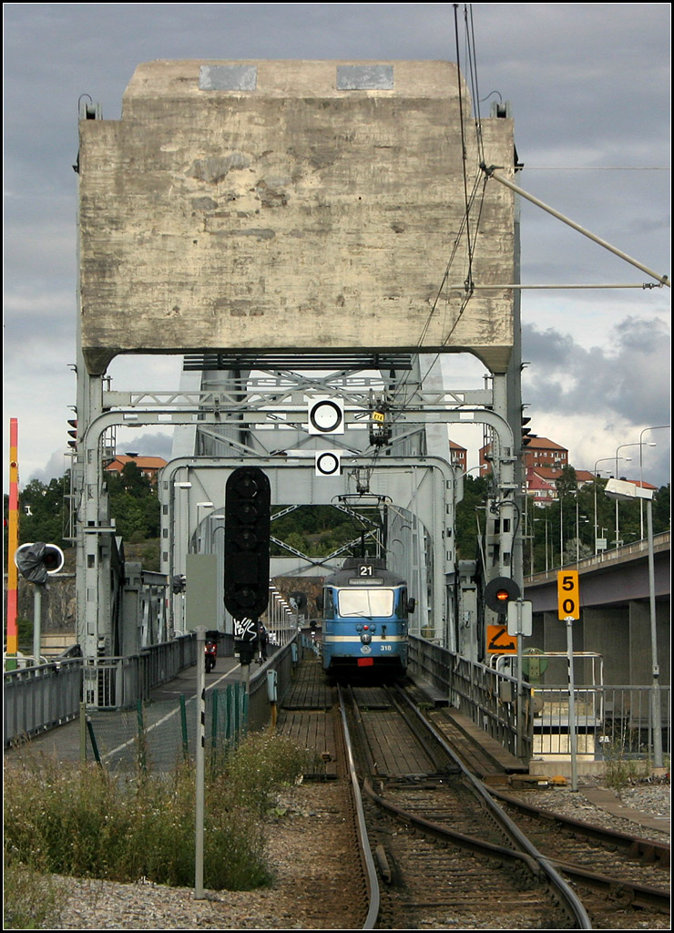 . Brücke mit Gegengewicht -

Lidingöbahn: Ein Straßenbahnzug auf der Brücke über den Lilla Värtan. Der Betonblock oben ist das Gegengewicht der Klappbrücke, auf der sich die Bahn gerade befindet. 

16.8.2007 (M)