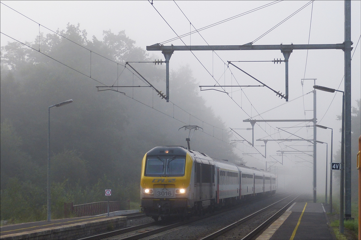  CFL 3016 mit Ihrem Zug in Richtung Lttich, kommt am morgen des 29.08.2017 aus der Nebelbank heraus und wird in krze den Bahnhof von Wilwerwiltz erreichen.  (Hans) 