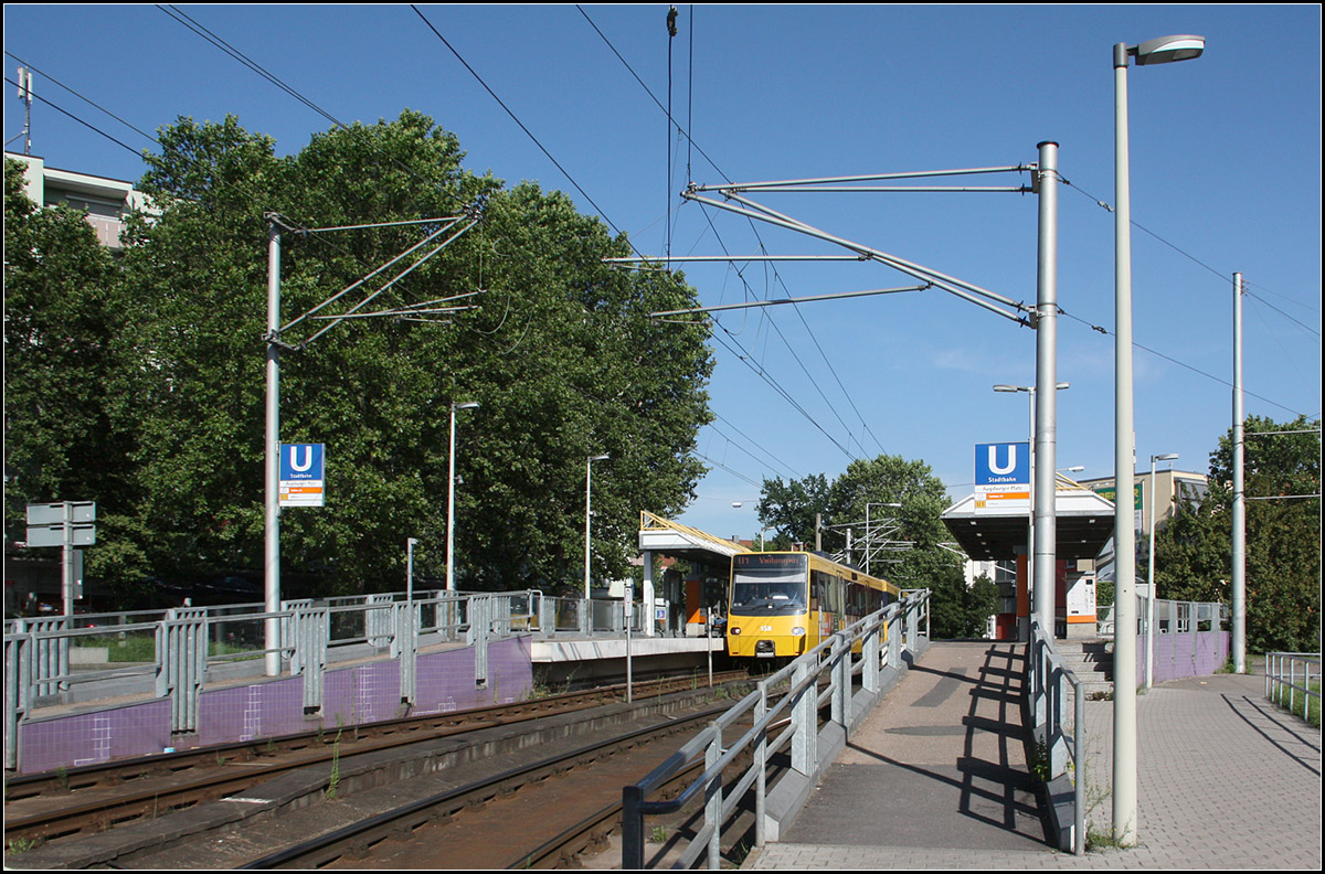 . Die Bäume sind größer -

... geworden im Vergleich zu 1979 auf Kurts Aufnahme:

http://www.bahnbilder.de/bild/deutschland~strassenbahn~stuttgart-keine-stadtbahn/609479/stuttgart-ssb-sl-1-gt4-454.html

Stadtbahnhaltestelle Augsburger Platz an der Linie U1 in Stuttgart-Bad Cannstatt.
Der 1er fährt seit 1986 als Stadtbahn. Erst 1989 wurden die Hochbahnsteige in individueller Gestaltung nachgerüstet. Rechts außerhalb des Bildes konnte bis vor wenigen Jahren in die U13 umgestiegen werden. Dort konnte aber kein Hochbahnsteig errichtet werden, diese Linie fährt jetzt hier ohne Halt vorbei.

Angedacht war (oder ist) auch die Haltestelle der Linie U1 hier aufzugeben und durch eine neue Station unter der Bahnbrücke weiter nordöstlich zu verlegen und mit der Station Nürnberg Straße zusammen zu legen.

27.07.2016 (M)