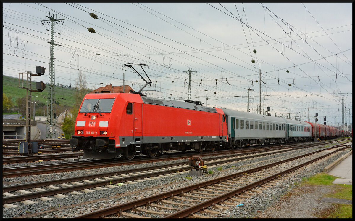  Die verkehrsrote TRAXX 185 317-5 (DB Cargo) kam am 17.04.2023 mit einem EZ durch Würzburg und fuhr nach kurzem Halt in Richtung Gemünden/Main weiter. An der Spitze des Zuges liefen zwei graue Personenwagen von DB Cargo mit. Bei diesen Waggons (D-DB 63 80 99-40 114-0 Bcmkh240 und D-DB 63 80 99-40 110-8 Bcmkh240 ) handelt es sich um Liege- und Begleiterwagen für Sonderverkehr wie z. B. Militärtransporte.