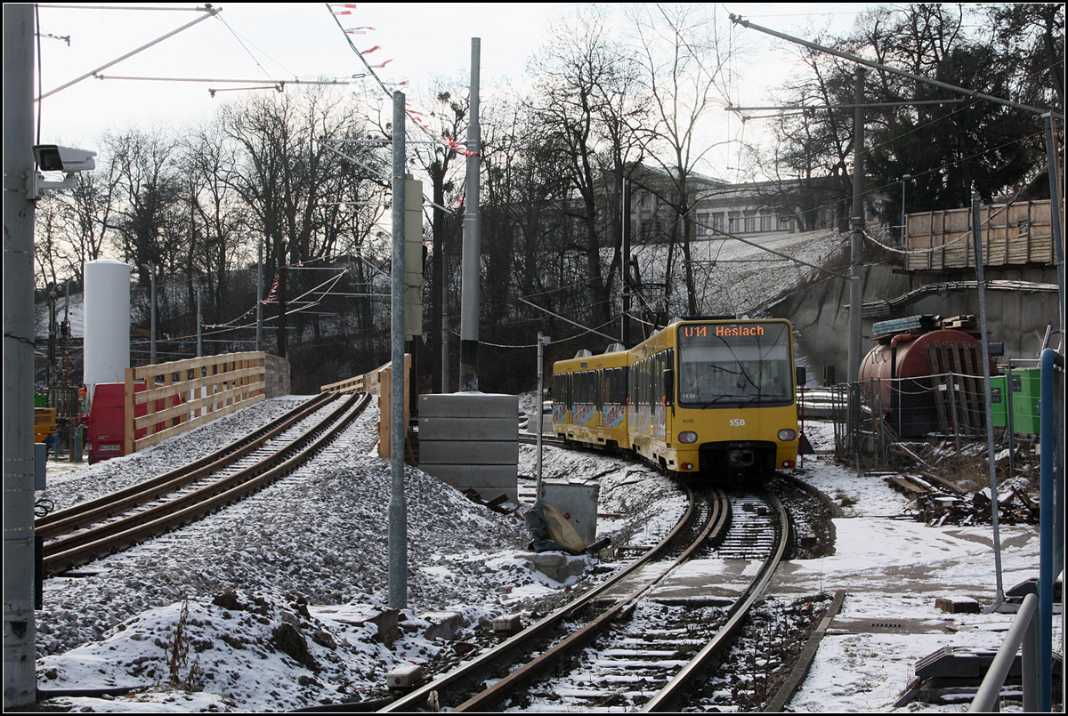 . Durch Baustellen -

An dieser Stelle lag vor der Verlegung die Stadtbahnhaltestelle Wilhelma. Jetzt quert die U14 auf eingleisiger Trasse den Baustellenbereich des Tunnelportals des B10-Rosenstein-Autotunnels. Die Stadtbahn wird bald auf ein Brückenprovisorium (links) verlegt, unter dem dann der Tunnel gebaut werden kann. Die endgültige Trasse wird dann ebenfalls über ein Kuppe führen. Jenseits dieser wird dann die neue Bahnbrücke (Stuttgart 21) unterquert. Oben im Hintergrund das Schloss Rosenstein.

18.01.2017 (M) 