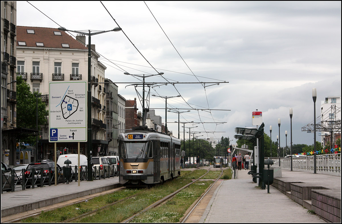 . Haltestelle am Brüssler Stadtrand und doch mitten in der Stadt -

Tramstation Porte de Flandre am Kanal Brüssel - Charleroi am Rande der Brüssler Innenstadt. Jenseits des Kanales liegt die selbständige Stadt Molenbeek-St-Jean. Die Stadt Brüssel selber hat lediglich ca. 170 000 Einwohner und ist damit kleiner als Antwerpen (503 000), Gent (249 000), Charleroi (202 000) oder Lüttich (197 000). Brüssel wird aber eher als Metropole erlebt mit über 1,1 Millionen Einwohnern erlebt. Diese Hauptstadt-Region besteht aber aus 19 unabhängigen Kommunen.

23.06.2016 (M)