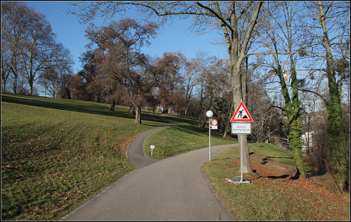 . Noch eine Parkanlage -

Aber sicherlich beginnen auch hier am Neckarhang des Rosensteinparkes bald die Bauarbeiten für Stuttgart 21. Da hinten wo oberhalb des breiten Weges die Bäume stehen werden die beiden Tunnelportale für die neuen Tunnelstrecken in Richtung Hauptbahnhof entstehen. Die Züge kommen dann von rechts über die neue Neckarbrücke und werden dann hier im Hang in die Tunnelröhren einfahren. Es wird zwei voneinander unabhängig geführte Röhren für die Fern- und Regionalbahn und für die S-Bahn geben, die sich am anderen Ende des Rosensteinparkes überkreuzen. Die Oströhre des Fernbahntunnels ist bis auf weniger Meter vom Hauptbahnhof bis zum Kreuzungspunkt mit der S-Bahn auf 2,9 km länge schon komplett aufgefahren, Unter dem Rosensteinpark sind beide Tunnels mit zweigleisigem Querschnitt geplant. Zur Orientierung bietet sich auch der Stadtplan an.

Der unbefestigte Weg rechts kommt vom Tunnelportal des längst stillgelegten Eisenbahntunnels, der direkt und dem Schloss Rosenstein hindurchführt.

10.12.2016 (M)