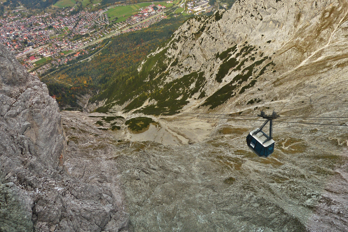 . Schwindelerregend - Aussicht von der Bergstation der Karwendelbahn (2244 Meter) auf eine talwrts fahrende Gondel und auf Mittenwald (933 Meter). 05.10.2015 (Hans)

Die Karwendelbahn ist eine Luftseilbahn von Mittenwald zur Karwendelgrube an der Westlichen Karwendelspitze.

Die Pendelbahn fhrt von der am Ortsrand von Mittenwald auf 933 m . NN gelegenen Talstation ber eine schrge Lnge von 2490 m zu der 2244 m . NN hoch gelegenen Bergstation und berwindet dabei einen Hhenunterschied von 1311 m. Sie hat zwei Seilbahnsttzen von 36 bzw. 20 Metern Hhe, die sich bei der Mittenwalder Htte und der Wanne befinden. Ihre beiden Kabinen fr je 25 Personen fahren mit einer Geschwindigkeit von maximal 10 m/s (36 km/h) und bentigen etwa sieben Minuten fr eine Fahrt. Die Frderleistung betrgt 350 Personen pro Stunde. Die Bahn hat auf jeder Fahrspur ein Tragseil mit 48 mm Durchmesser sowie ein Zugseil mit 23 mm und ein Hilfsseil, an dem im Notfall die beiden Bergewagen zu den Kabinen fahren knnen.

Mit dem Bau der Karwendelbahn wurde 1954 begonnen, konnte aber erst am 7. Juni 1967 erffnet werden. 1992 wurde sie modernisiert.

Die Seilbahn wird von der Karwendelbahn Aktiengesellschaft betrieben
