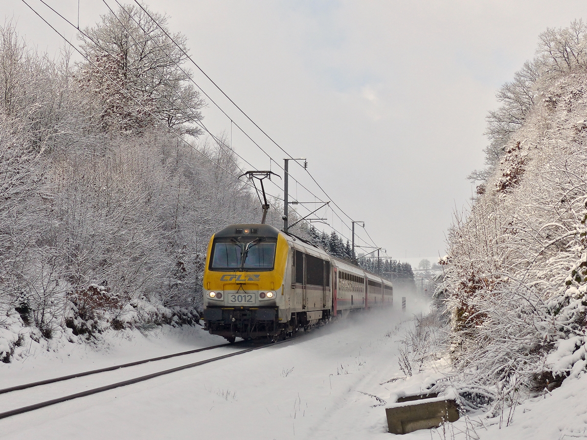 . Winter an der luxemburgischen Nordstrecke - Ein kleines Stck blauen Himmels zeigte sich am 02.02.2015 an der Nordstrecke zwischen Troisvierges und Maulusmhle, als der IC 112 Liers - Luxembourg, gezogen von der 3012, durch das frisch verschneite Tal der Woltz fuhr. (Jeanny)