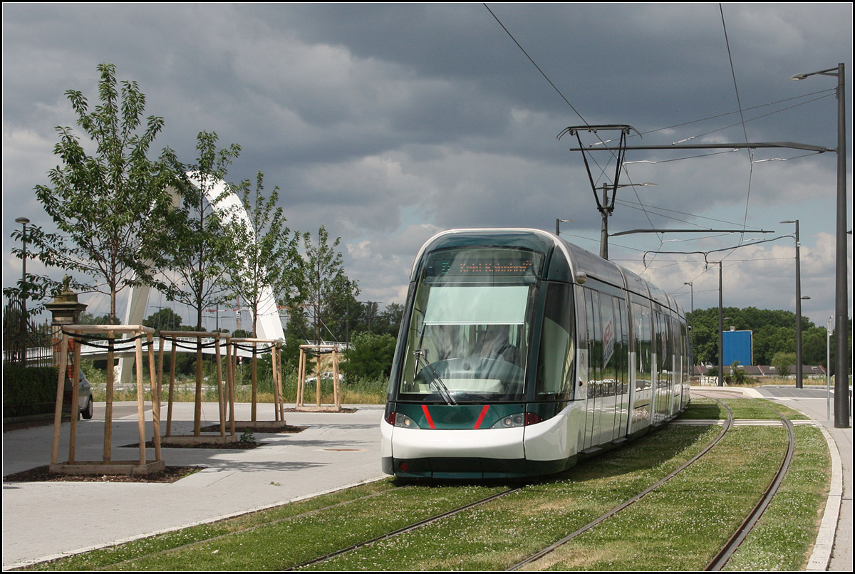 . Ziel Kehl Bahnhof - 

Eine Citadis-Tram auf der Straßburger Linie D auf der Fahrt ins deutsche Kehl bei der noch geschlossenen Haltestelle 'Starcoop'. Im Hintergrund hinter den Bäumen der große Bogen der zweiten markante Brücke entlang der Neubaustrecke.

25.06.2017 (M)