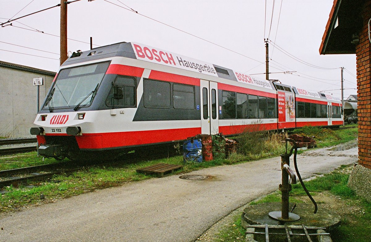 03. November 2002, auf dem Betriebshof der Fa. Stern & Hafferl in Eferding bei Linz steht der Triebzug 22 152 der Linzer Lokalbahn. Eine gewisse Hinterhofromantik kontrastiert zum modernen Zug. Scan vom Negativ. 