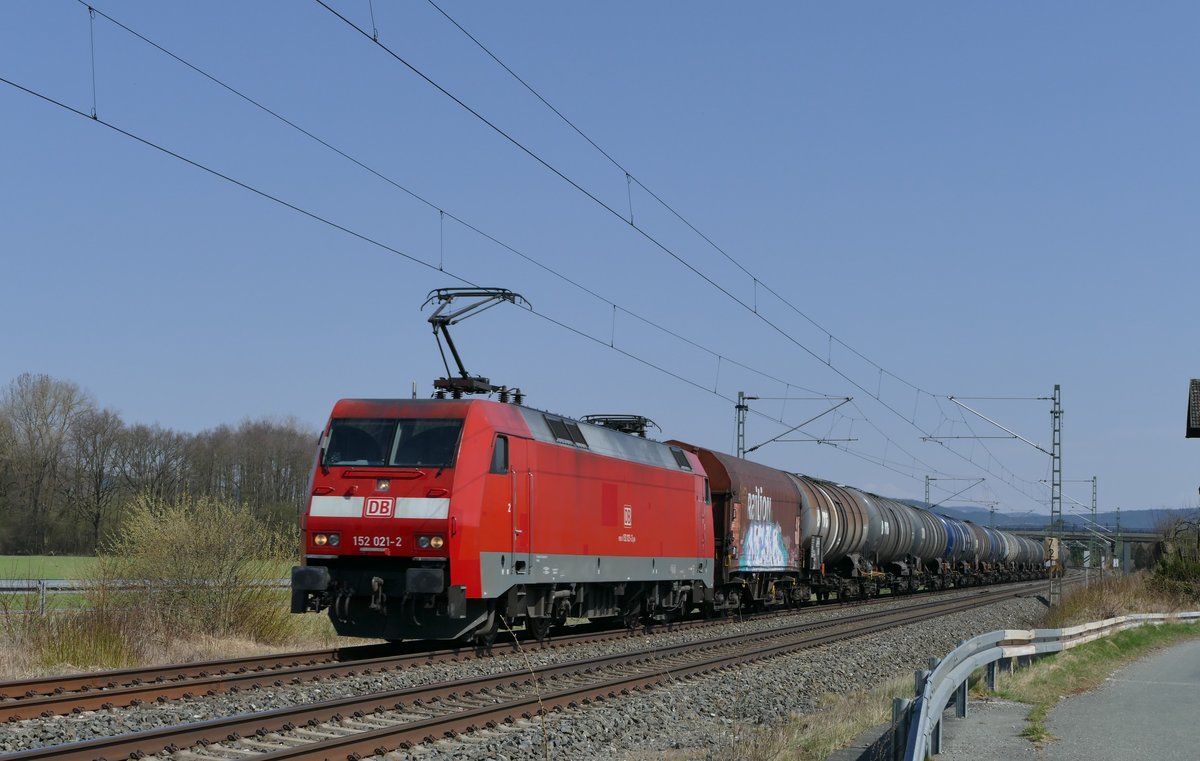 10. April 2018, Lok 152 021 fährt mit einem Güterzug in Richtung Lichtenfels am ehemaligen Haltepunkt Oberlangenstadt vorüber.