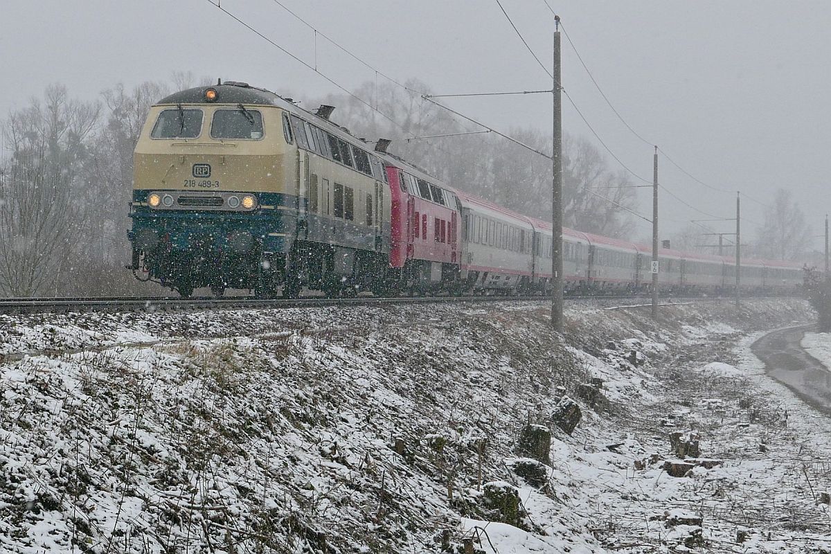 10.02.2021 und es schneit schon wieder am Bodensee - 218 489-3 und 218 319-2, beide von der Railsystems RP GmbH, ziehen bei Eriskirch die in Lindau-Insel bernommenen Wagen des IC 118  BODENSEE , Innsbruck - Bochum, dem zweiten Halt in Deutschland, Friedrichshafen entgegen.
