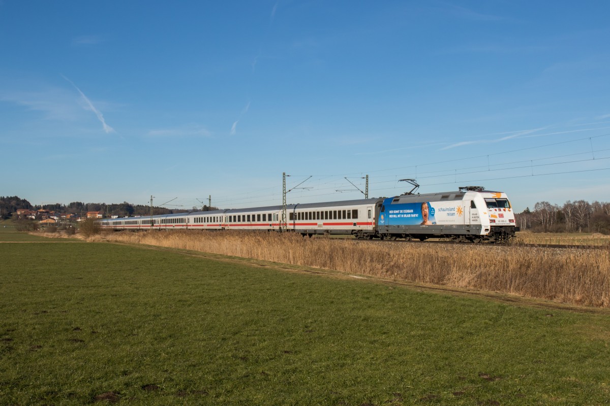 101 055 macht für  Schau ins Land Reisen  Werbung und ist damit beschäftigt, den EC 217 von Saarbrücken nach Graz zu fahren, hier zu sehen bei Bernau am Chiemsee am 28. Dezember 2015.