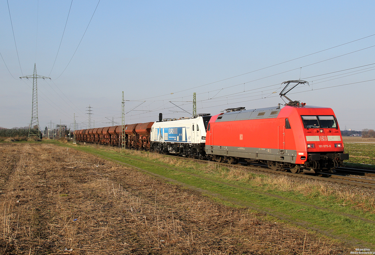 101 075 mit der Überführung einer Stadler Euro 9000 bei Hürth-Fischenich am 07.03.2021