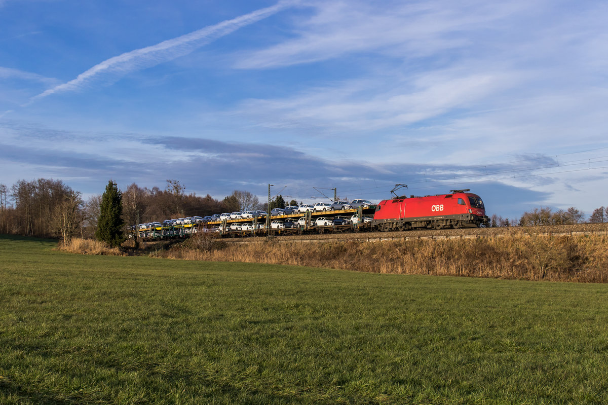 1016 007 fährt mit einem Autozug bei Großkarolinenfeld in Richtung Salzburg, aufgenommen am 13. Dezember 2016.
