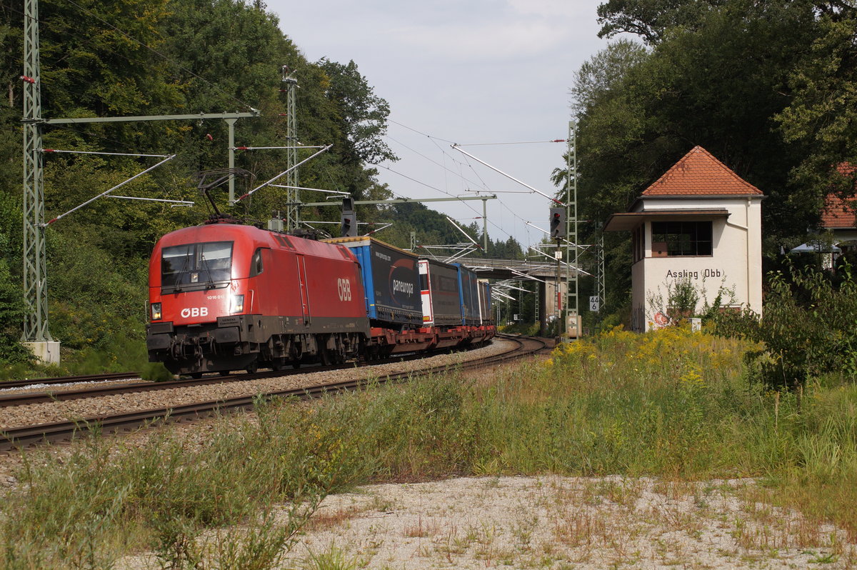 1016 015 der ÖBB vor Güterzug mit Taschenwagen und Lkw-Aufliegern bei der Einfahrt in den Bahnhof Aßling (Strecke München-Rosenheim).
Aßling, 31.08.2017