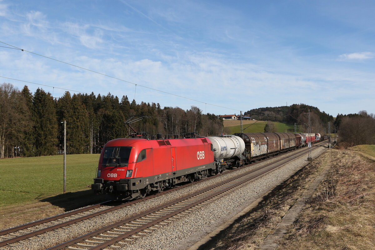 1016 023 war mit einem gemischten Güterzug am 22. Februar 2023 bei Hütt im Chiemgau in Richtung München unterwegs.