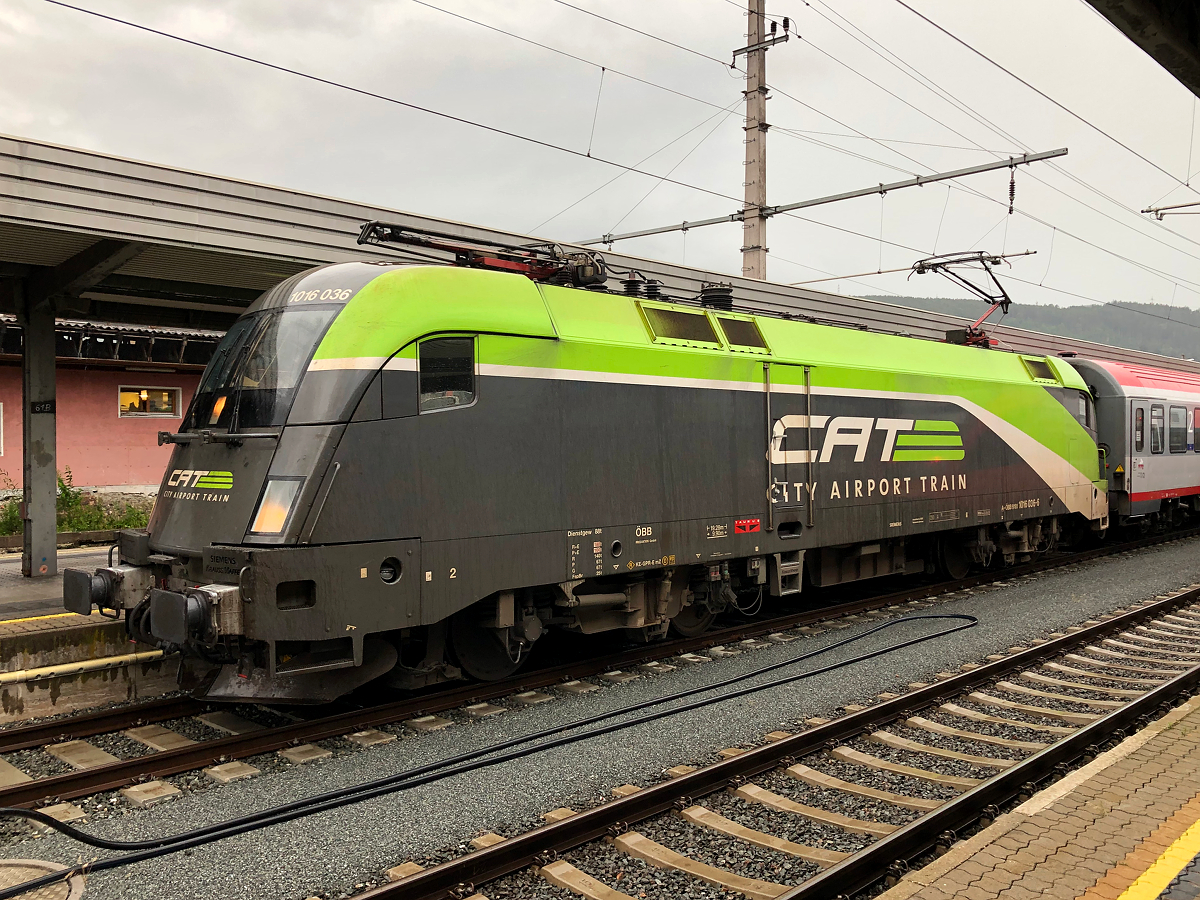 1016 036-6  CAT - City Airport Train  wartet mit ihrem REX 5333 am Bahnsteig 6 auf die Abfahrt nach Kufstein. Zum Zeitpunkt des Fotos herrschte ein heftiges Gewitter. Innsbruck Hbf am 13.07.2021