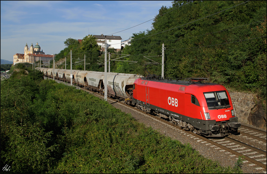 1016.015 fährt am 27.08.15 mit Getreidezug die Westbahn bei Melk entlang.
Im Hintergrund das Benediktinerkloster Stift Melk.