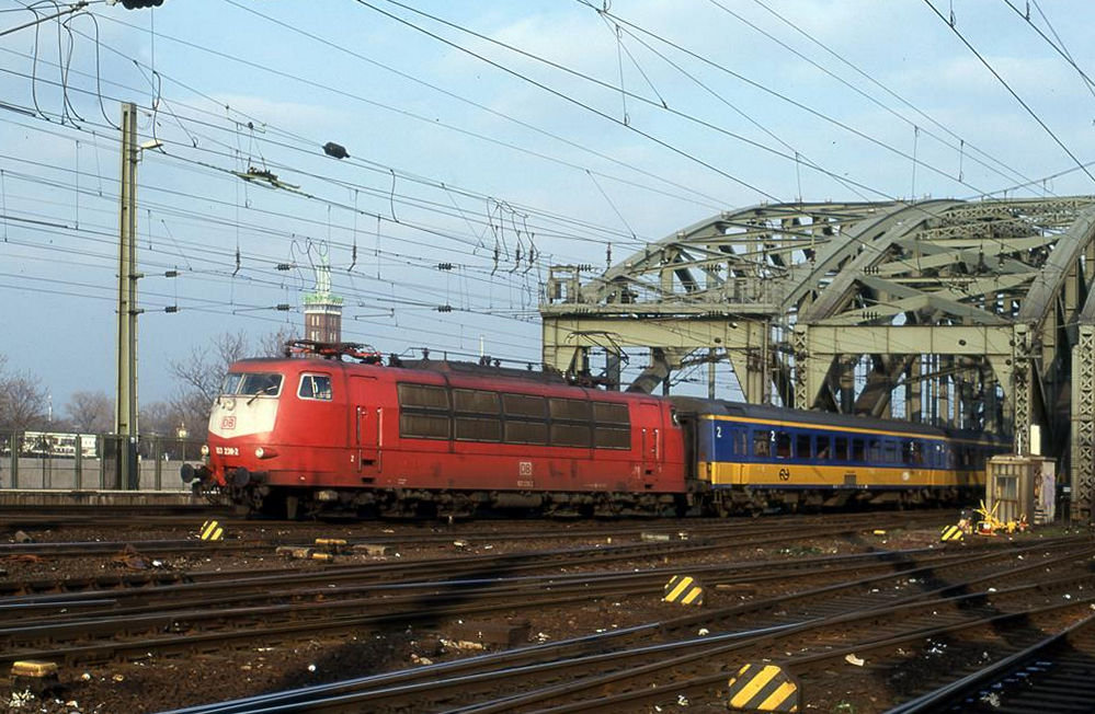 103238 verläßt mit einer niederländischen IC Garnitur nach Eindhoven am 24.3.1999 um 16.59 Uhr die Hohenzollernbrücke in Köln und fährt in den HBF Köln ein.