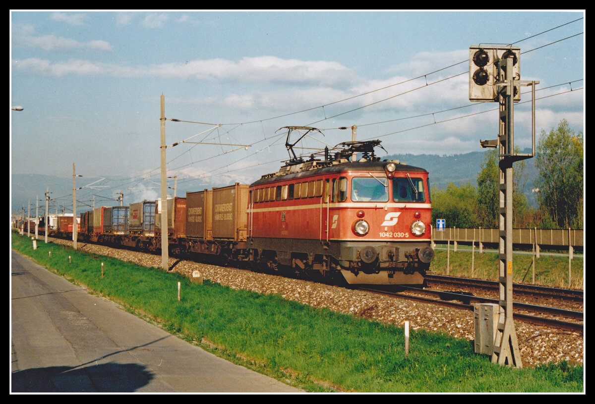 1042 030 fährt am 28.04.1995 mit einem langen Güterzug bei Niklasdorf durchs Murtal. Dieses Bild ist heute nicht mehr möglich da sich an dieser Stelle eine hohe Schallschutzwand befindet.