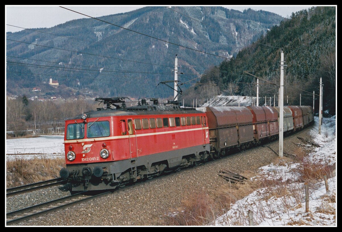 1042 041 fährt am 25.02.2004 mit einem schweren Kokszug bei Niklasdorf durchs Murtal.