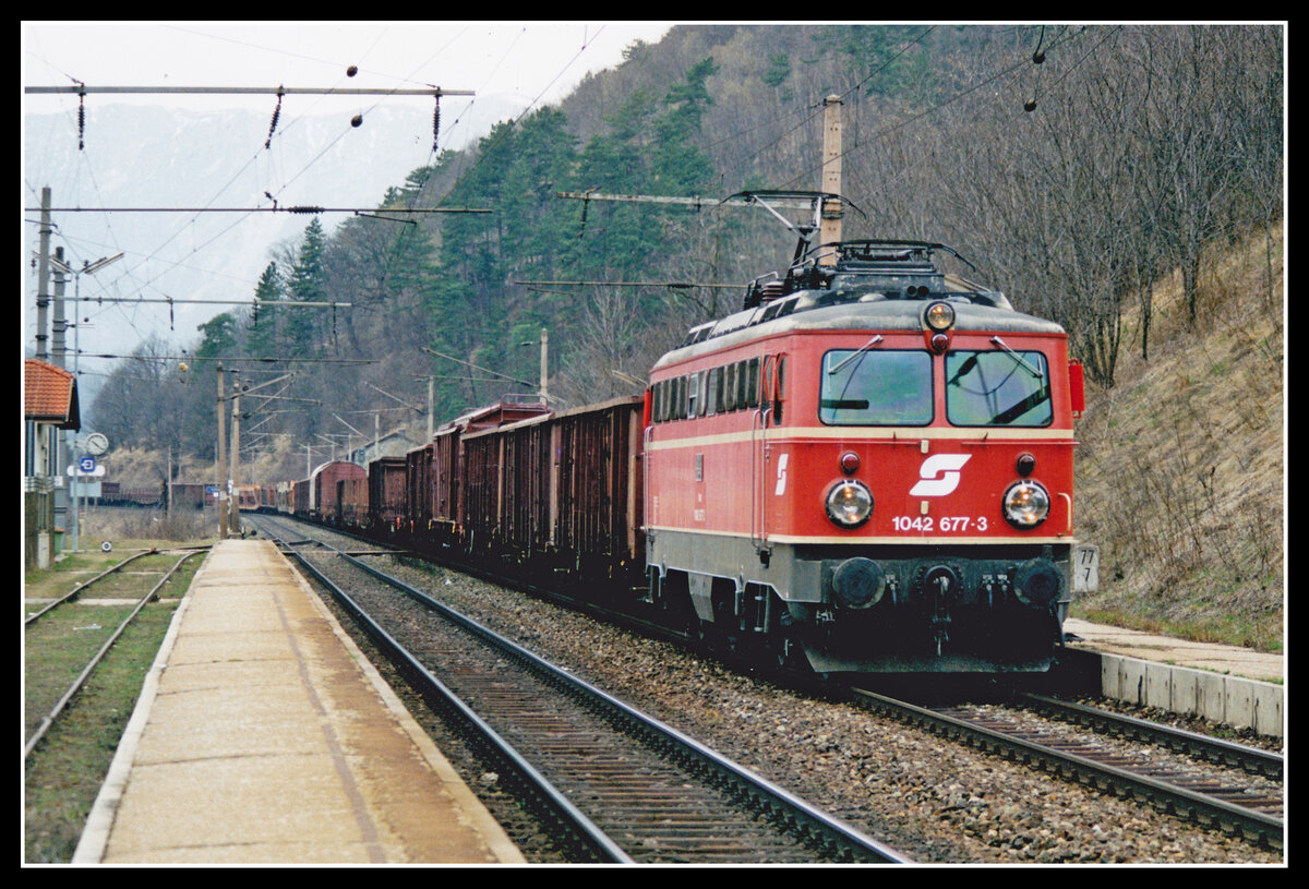 1042 677 fährt am 4.03.1998 mit einem Güterzug durch die Haltestelle Schlögmühl. Damals herrschte auf der Südbahn noch Linksverkehr der zwischenzeitlich auf Rechtsbetrieb geändert wurde.