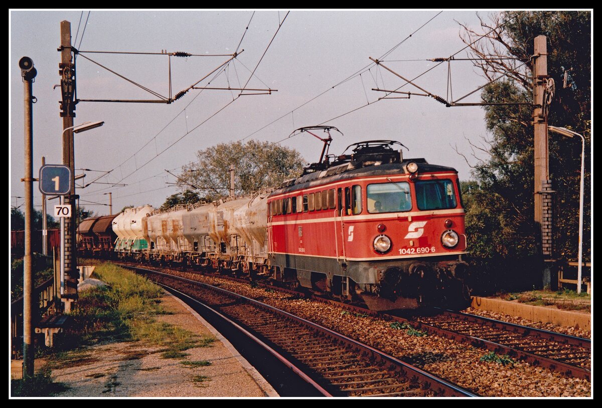 1042 690 fährt am 22.09.1994 mit einem Güterzug durch die Haltestelle Lobau.