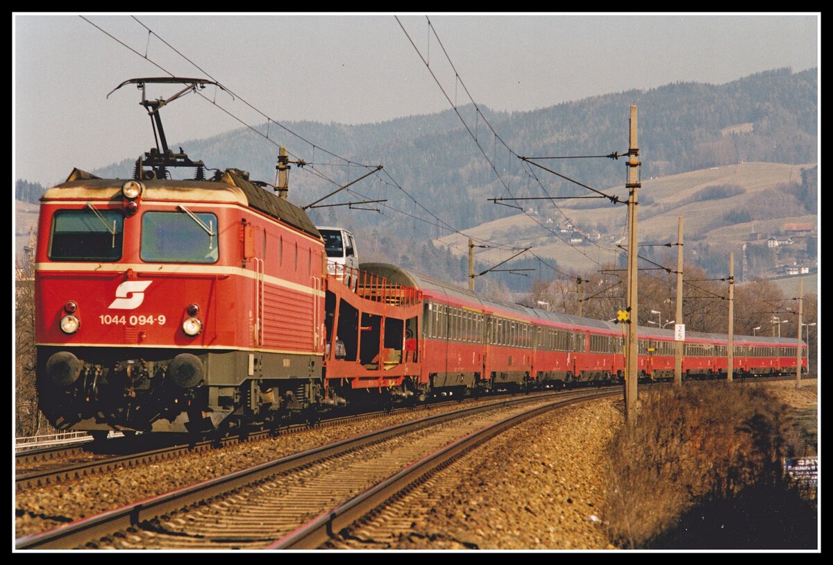 1044 094 zieht am 28.02.2000 IC668 (Graz - Bregenz) kurz nach Bruck an der Mur durchs Murtal. Als erster Wagen ist der Autotransportwagen gereiht der bis Feldkirch am Zug bleibt.