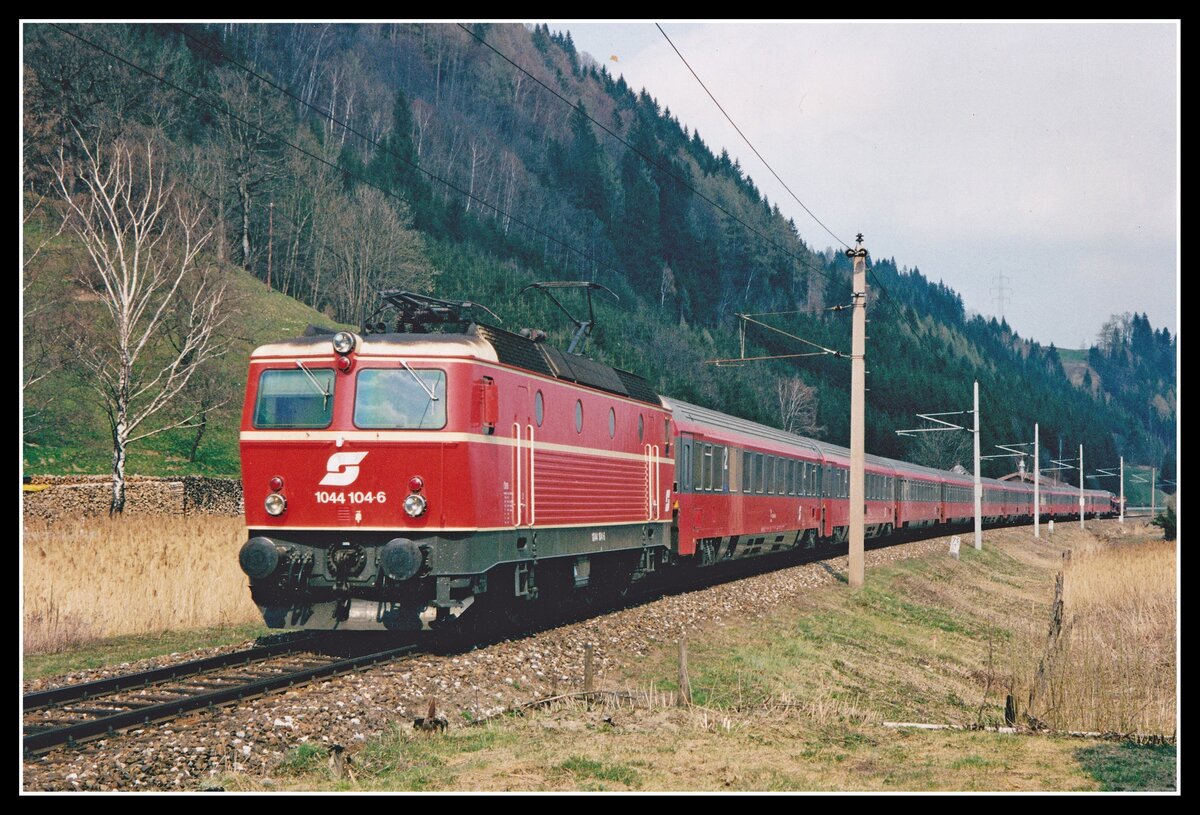 1044 104 fährt am 3.04.2002 mit IC668 (Graz - Bregenz) bei St.Martin am Grimming durchs Ennstal. Damals gab es noch viele 1044 mit ihrer originalen blutorangen Lackierung.