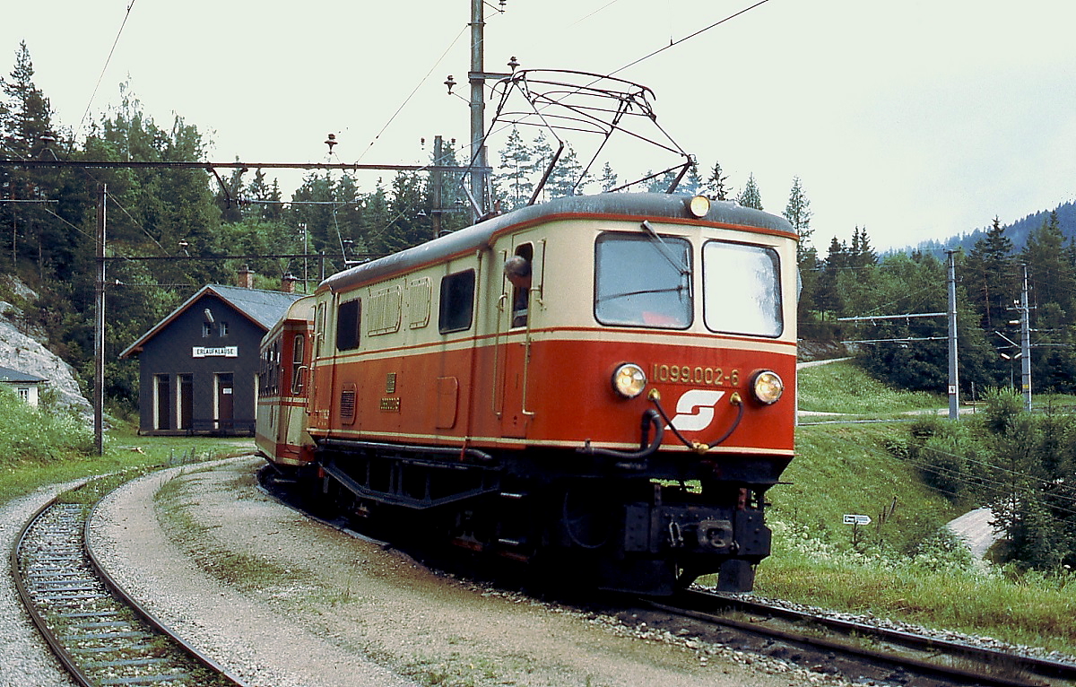 1099 002-6 der Mariazellerbahn (noch mit altem Nummernschild) im Juni 1991 im Bahnhof Erlaufklause. Der Lokführer muss schon ganz genau hinsehen, um das Abfahrtszeichen des Schaffners zu sehen.