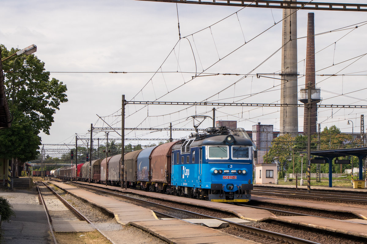 11. Juli 2019 in Nymburk: 130 021-9 durchfährt den Bahnhof mit einem schönen langen Mischer.