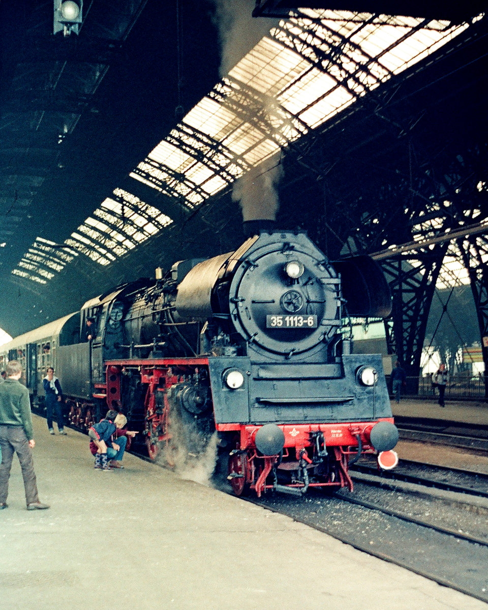 11. Juni 1983, Im noch recht dunklen Dresdener Hauptbahnhof. Lok 23 1113 (DR-Baureihe 35) steht zur Übernahme eines Sonderzuges bereit. Von 1982 bis 1985 wurde die Lok noch regelmäßig im Plandienst eingesetzt, obwohl sie seit dem 1.Januar 1982 offiziell zum Traditionslokpark der DR gehörte. Ab 1986 beförderte sie nur noch Sonderzüge. Sie gehört dem DB Museum Nürnberg, befindet sich als Leihgabe an die IG Dampflok Nossen im dortigen Depot.