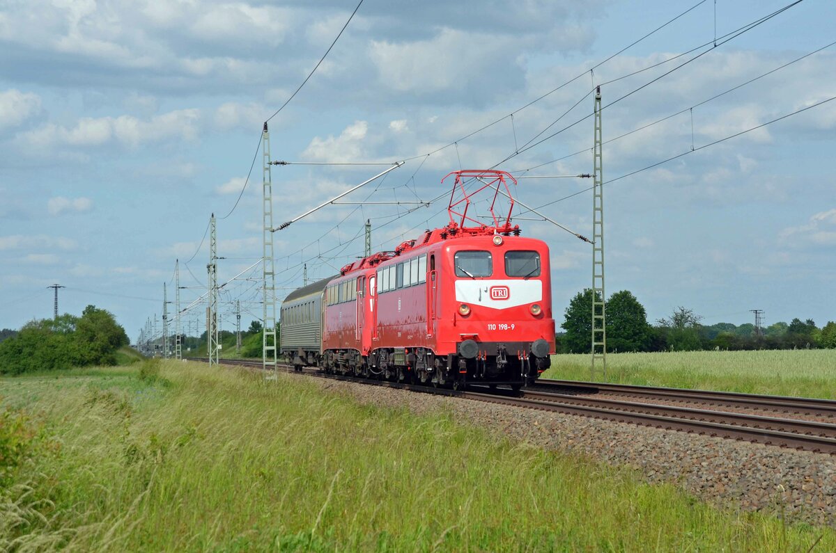 110 198 der TRI und 110 459 der GfF rollten mit einem TRI-Personenwagen am 30.05.23 durch Gräfenhainichen Richtung Bitterfeld. Auch diese beiden Loks waren zu Gast beim Orientrot-Treffen in Wittenberg.